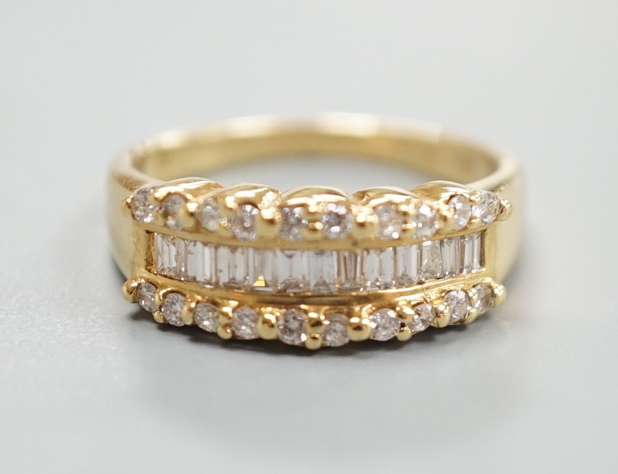 A modern 18ct gold and three row baguette cut diamond and diamond chip set half hoop ring, size M, gross weight 4 grams.